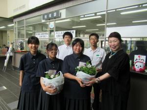 菊池南中学校の生徒５人と菊池警察署長が寄せ植えと一緒に写っている写真