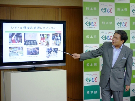 パワーポイントでクマモトオイスターの説明をする知事の写真