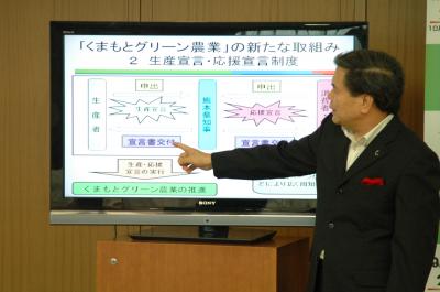 パワーポイントで説明する蒲島知事の写真