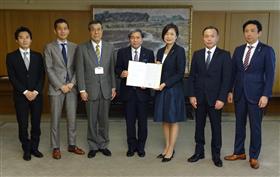 出席者と協定書を持ち記念撮影に応じる蒲島知事の画像