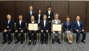 救急医療功労者全体写真（前列右から熊本県医師会　福田会長、東病院　東総合診療部長、東理事長、蒲島知事、人吉医療センター　木村院長、中川医事課長、木村副知事、後列右から池田医監、早田健康福祉部長、三牧健康局長）