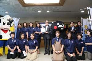 知事への牛乳贈呈の様子（©2010　熊本県　くまモン）