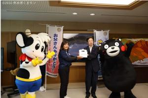 熊本県酪農女性部協議会内ケ島美津代会長から牛乳の贈呈を受ける木村知事の写真